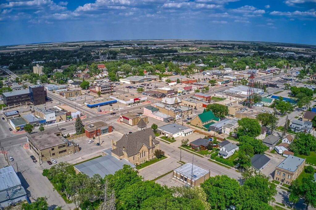 Aerial view of Portage la Prairie in Manitoba with residential neighborhoods and green fields.